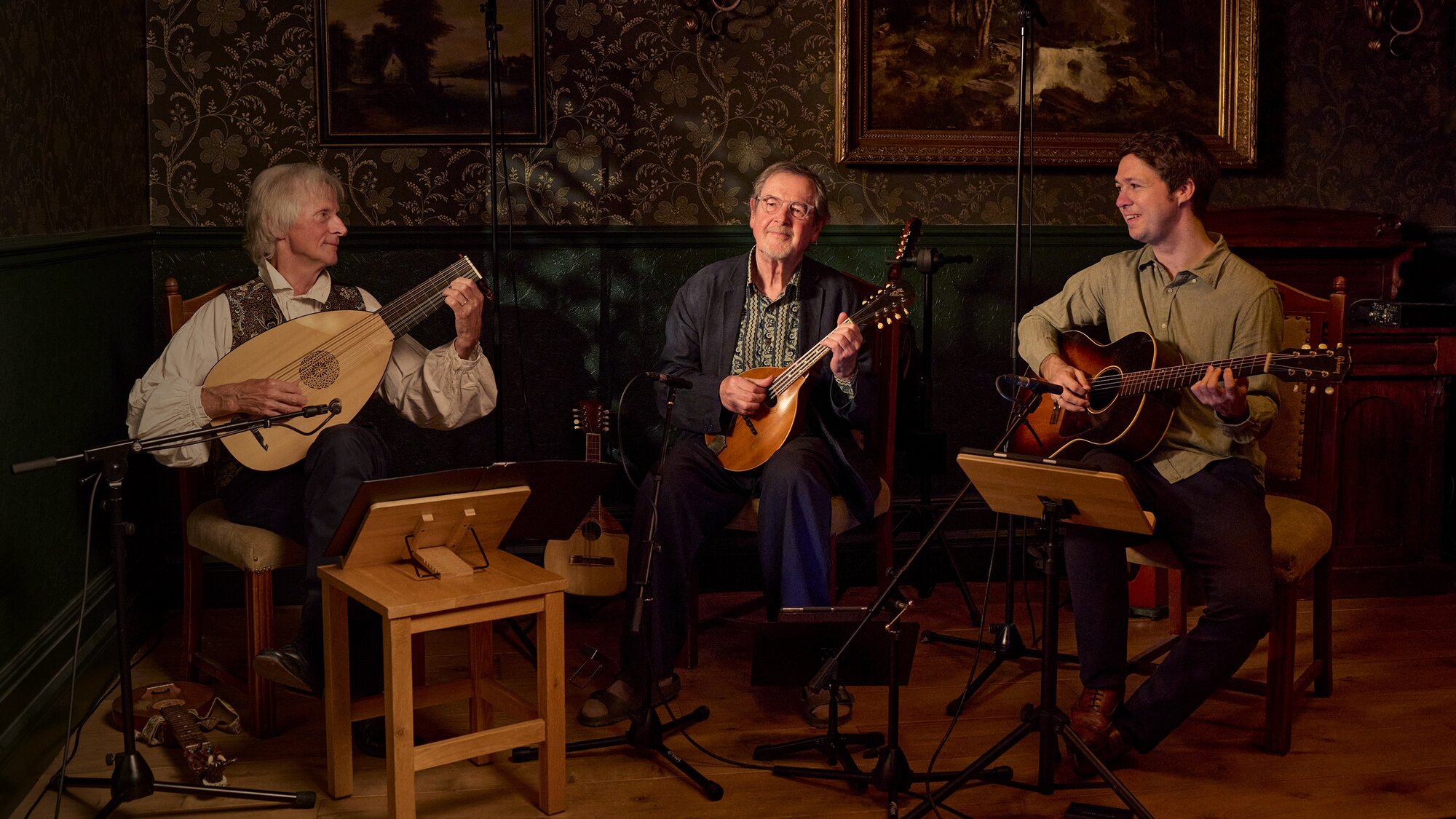 A trio of men playing fretted string instruments