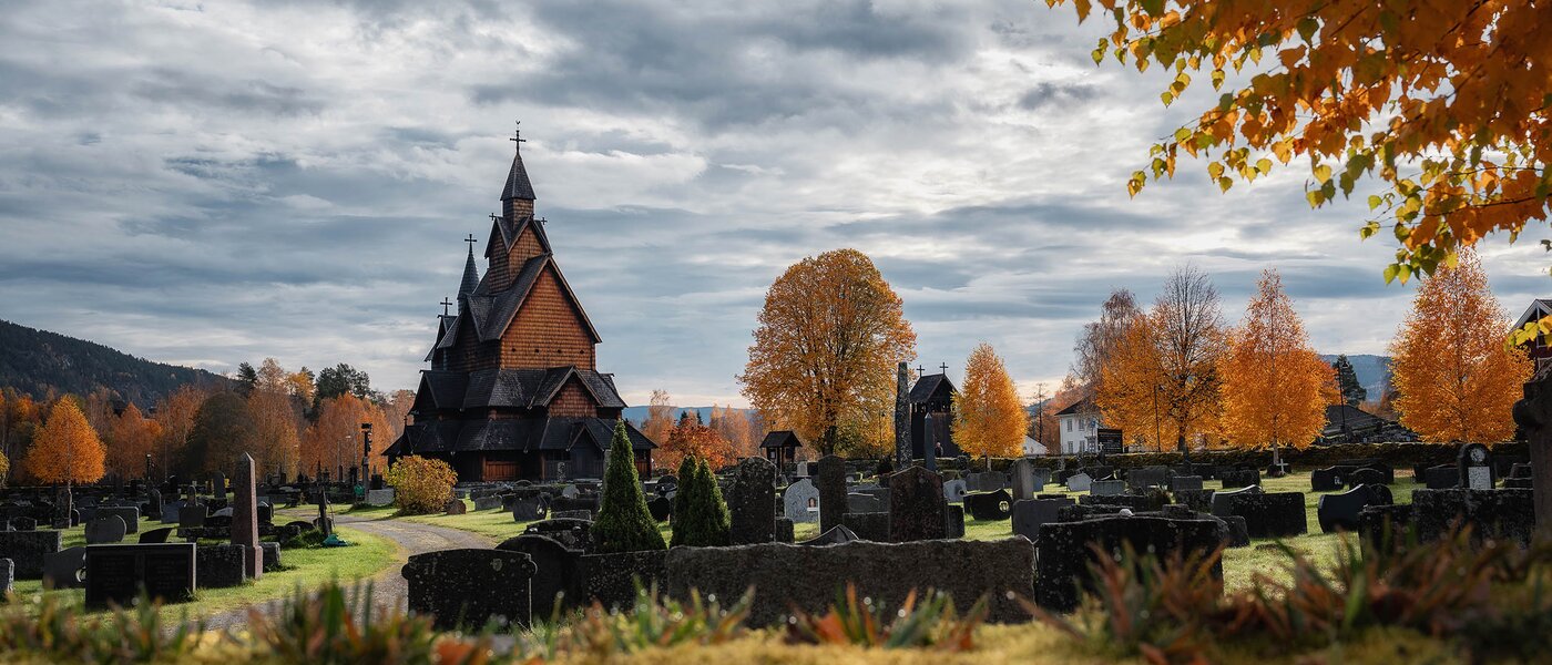 A stave church with a cemetery in the foreground