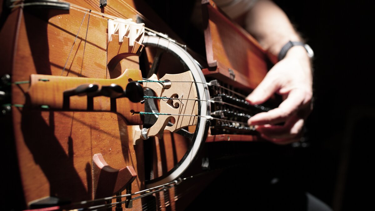 A close-up of hands on a hurdy-gurdy