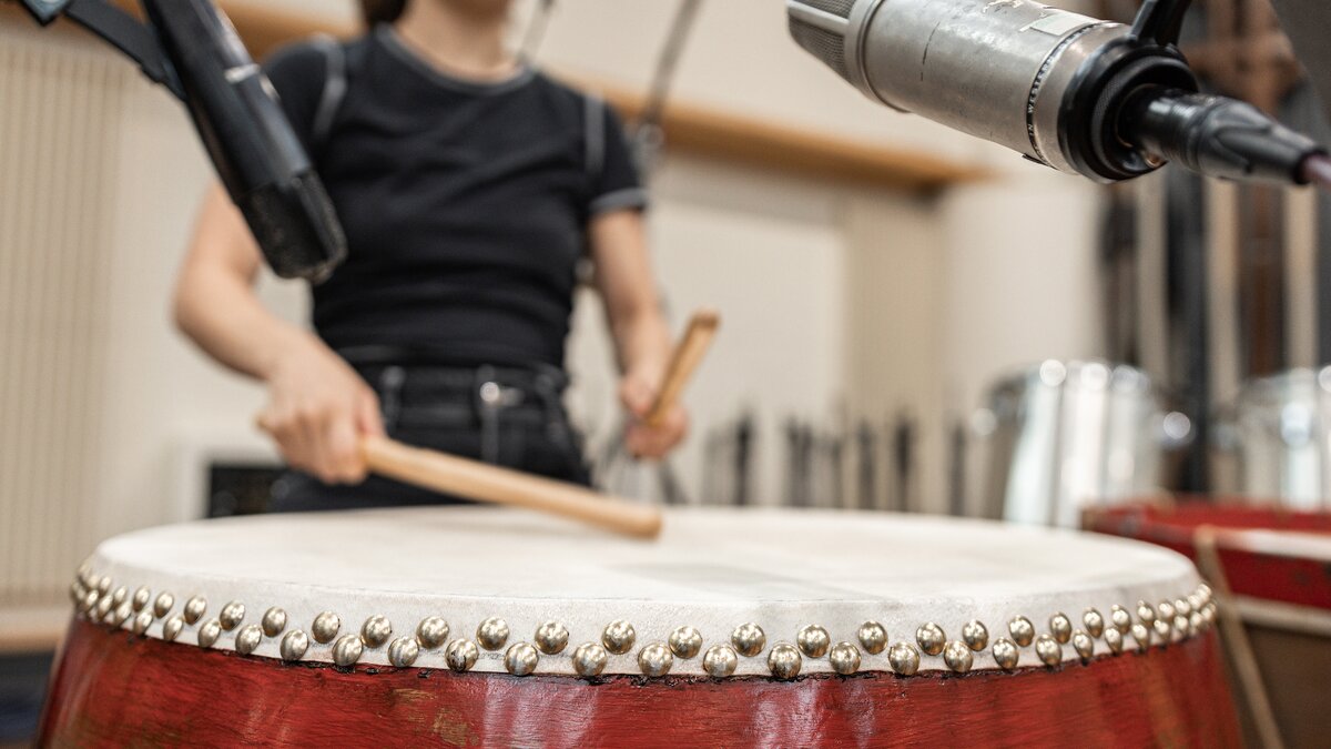 Close up of a woman playing a large drum. Photo by Marco Zappalà.