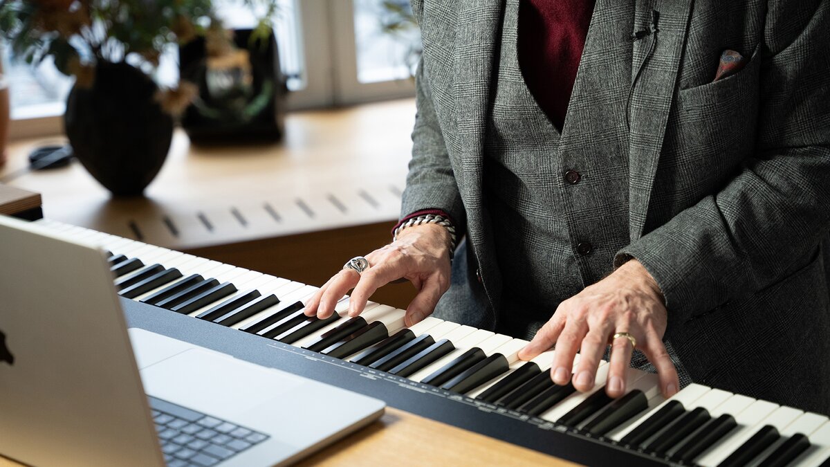 Close-up of Alexander Hacke playing a keyboard.