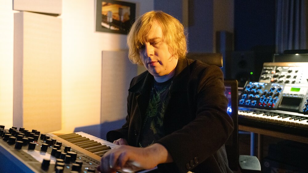 Dominik Eulberg adjusts a knob on a synthesizer.
