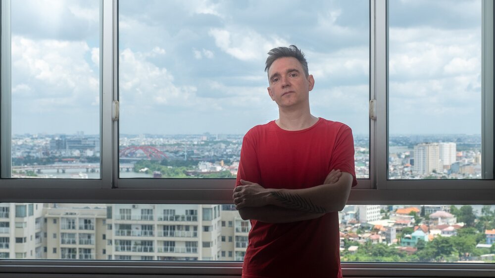 Peter Van Hoesen in front of a window overlooking Ho Chi Minh City