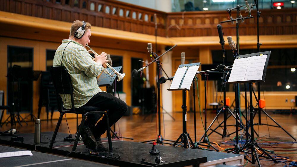 A man recording a trumpet in a large space