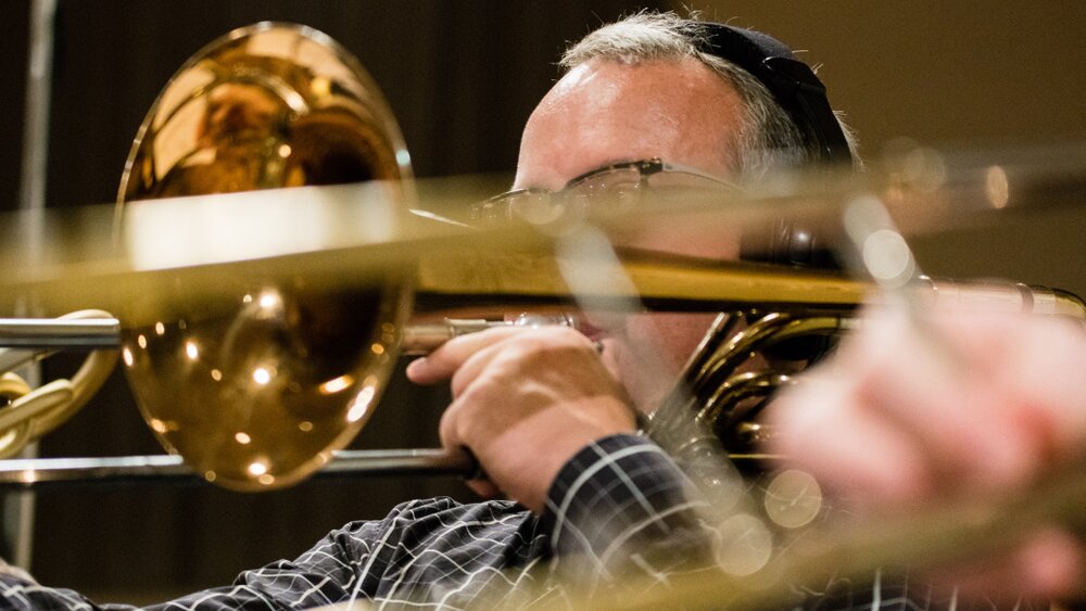 Close-up of a trombone section in a recording session