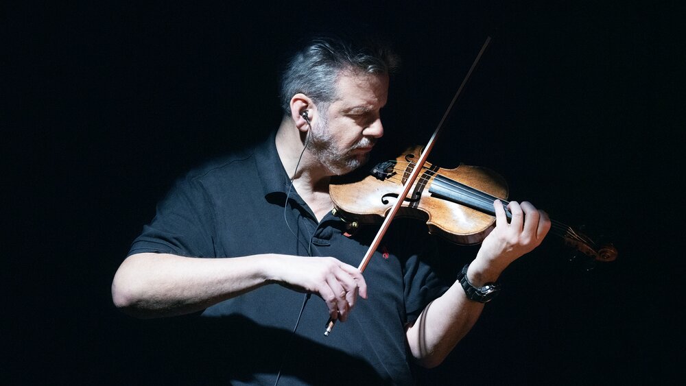 Violin player in high-contrast lighting