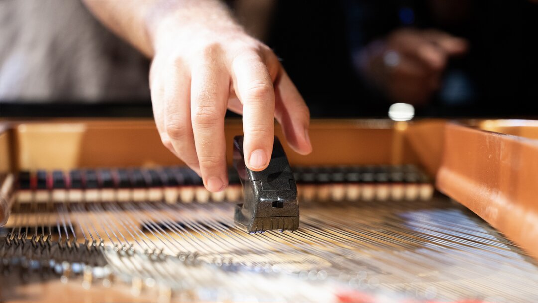 Using an ebow on a piano. Photo by Larissa Matheus.