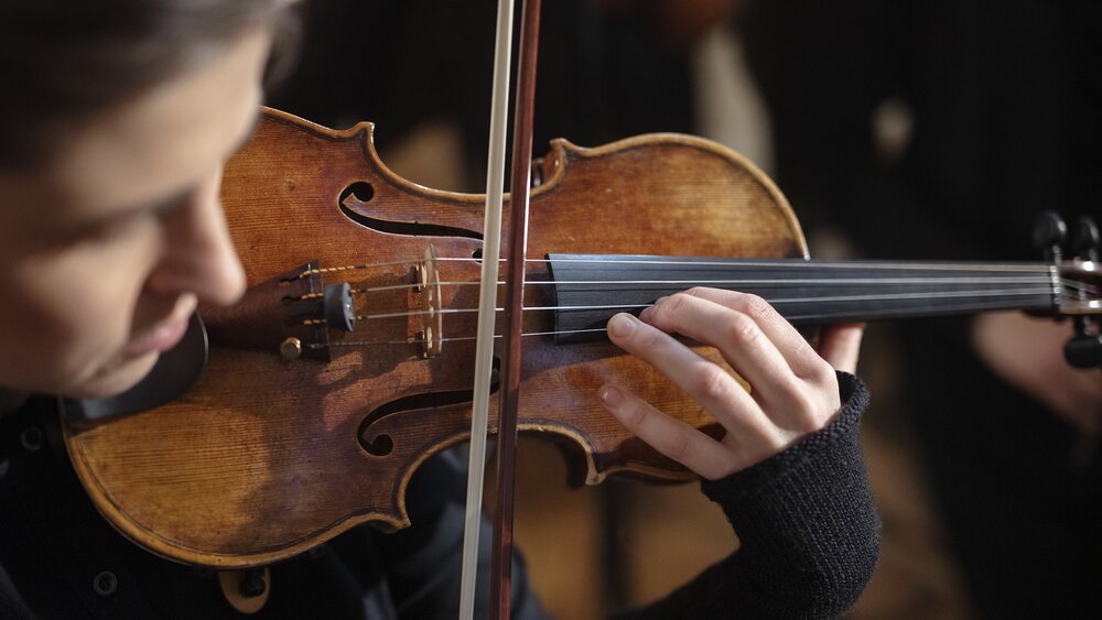 Close up of violin being played. Photo by Reinis Hofmanis.