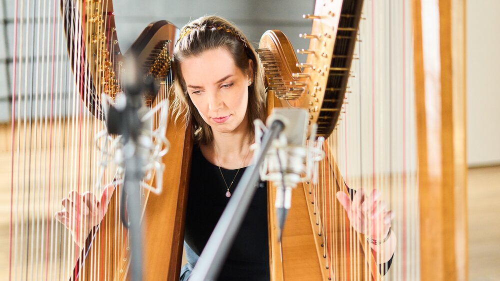 Liis Jürgens playing two harps simultaneously for the Salu sample library. Photo by Kaupo Kikkas.